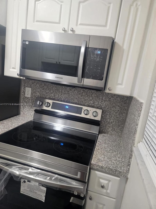 kitchen with white cabinetry, stainless steel appliances, and decorative backsplash