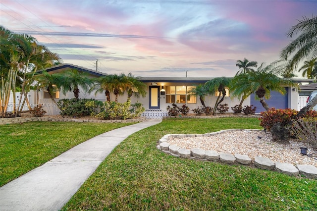 single story home with a yard and a garage