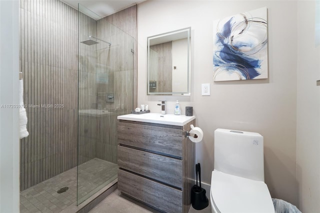 bathroom featuring a shower with door, vanity, and toilet