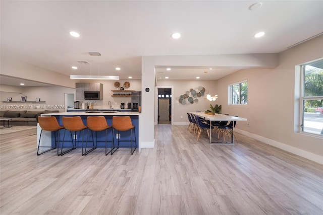 kitchen with a breakfast bar, sink, and light hardwood / wood-style flooring