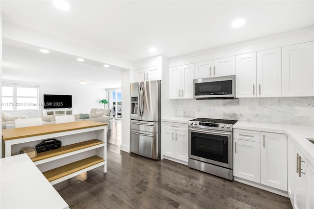 kitchen with dark hardwood / wood-style flooring, backsplash, stainless steel appliances, and white cabinets