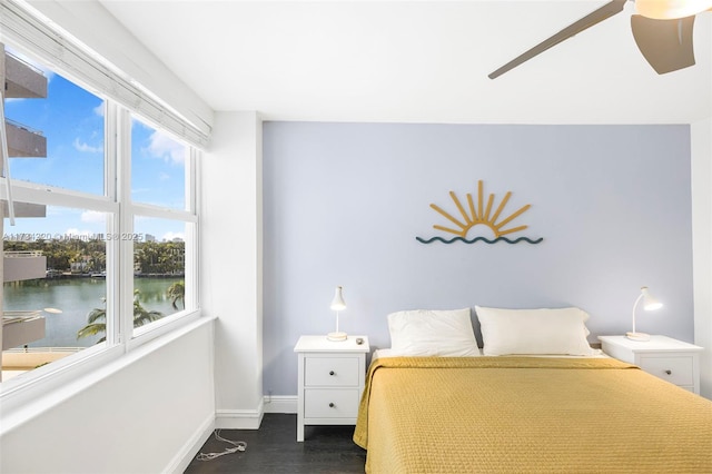 unfurnished bedroom featuring dark wood-type flooring and a water view