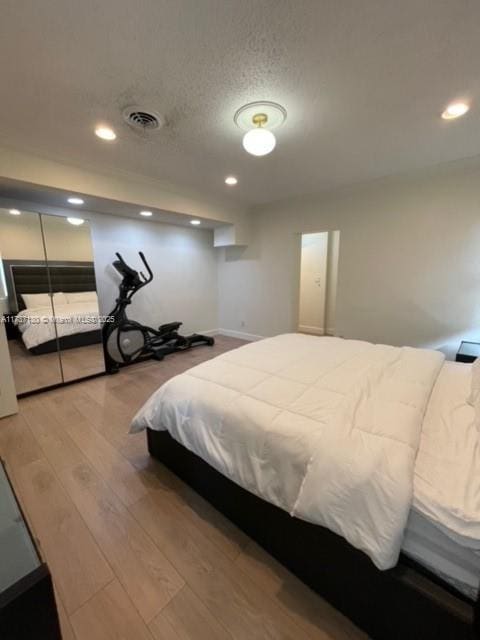 bedroom featuring wood-type flooring and a textured ceiling