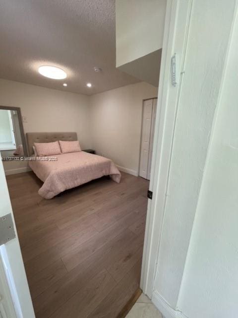 bedroom featuring hardwood / wood-style floors and a textured ceiling