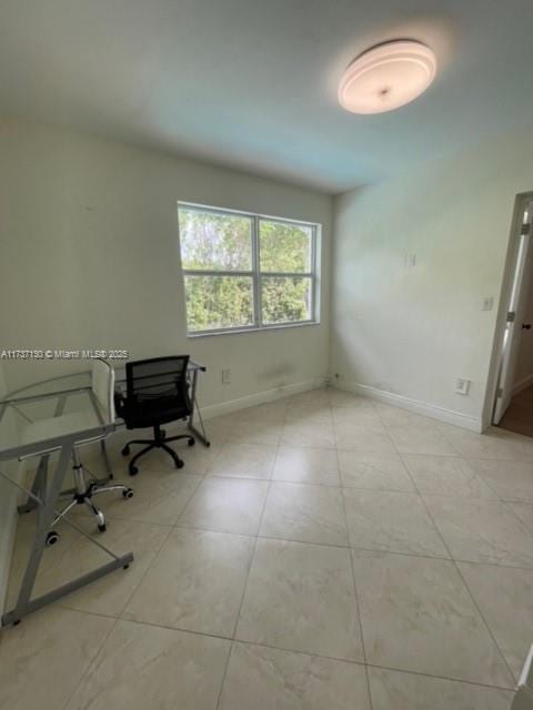 unfurnished office with light tile patterned floors