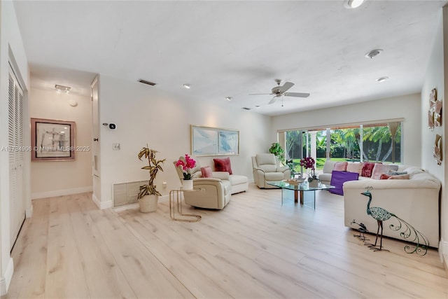 living room featuring ceiling fan and light hardwood / wood-style floors