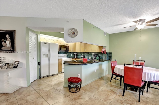 kitchen with tasteful backsplash, vaulted ceiling, light tile patterned floors, kitchen peninsula, and white appliances