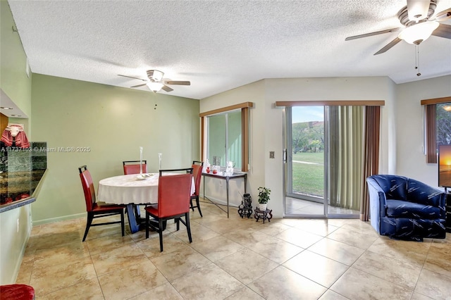 tiled dining space featuring a textured ceiling and ceiling fan