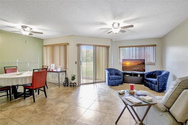 living room featuring light tile patterned flooring, a textured ceiling, and ceiling fan