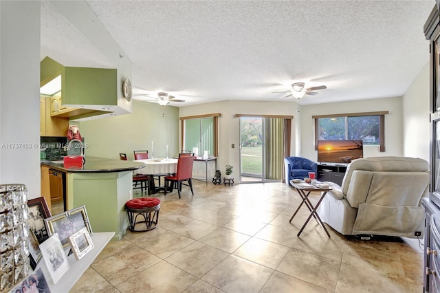 tiled living room with sink, a textured ceiling, and ceiling fan