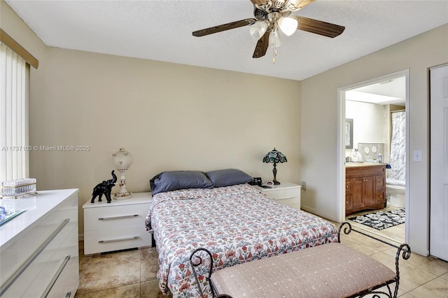 bedroom featuring ceiling fan, ensuite bathroom, a textured ceiling, and light tile patterned flooring