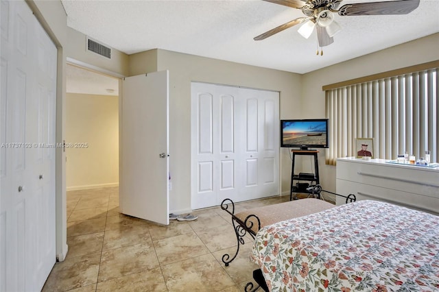 tiled bedroom featuring ceiling fan, a closet, and a textured ceiling