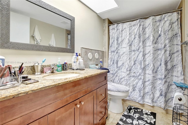 bathroom featuring vanity, toilet, and tile patterned flooring