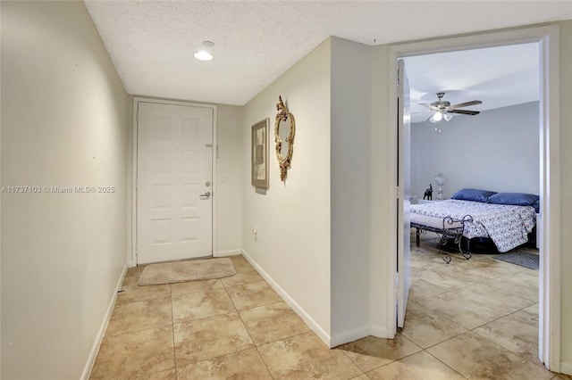 corridor featuring light tile patterned floors and a textured ceiling