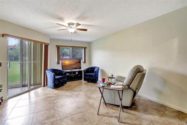 sitting room with light tile patterned floors, a textured ceiling, and ceiling fan