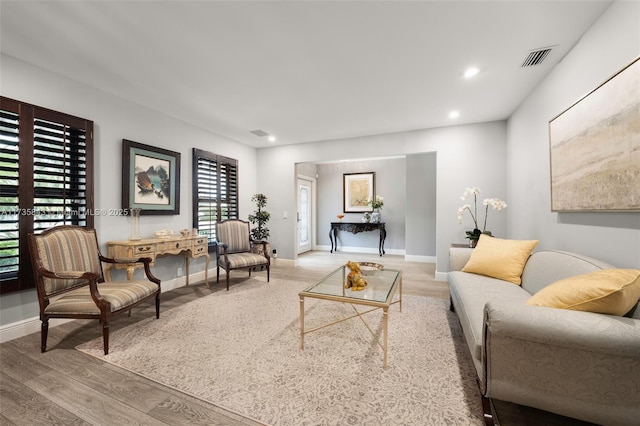 living area with visible vents, recessed lighting, baseboards, and wood finished floors