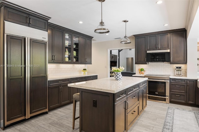 kitchen with dark brown cabinetry, light wood-style flooring, and stainless steel range with electric cooktop