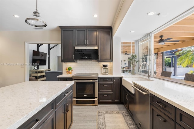 kitchen with tasteful backsplash, visible vents, light stone counters, stainless steel appliances, and a sink