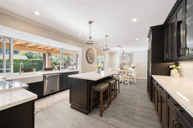 kitchen with a wealth of natural light, backsplash, a center island, and stainless steel dishwasher