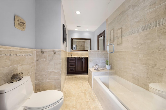 bathroom with toilet, a bathing tub, recessed lighting, tile walls, and vanity