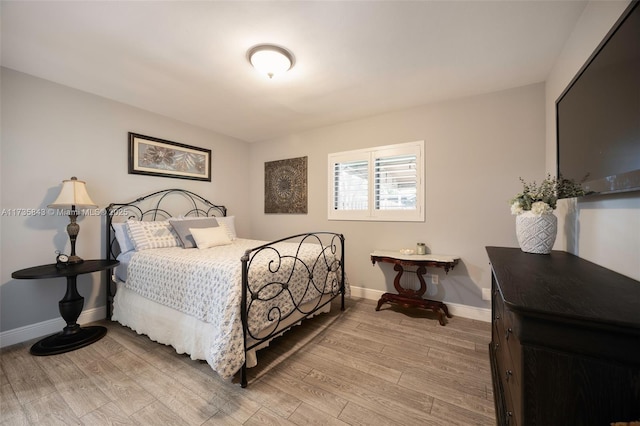 bedroom with light wood-type flooring and baseboards