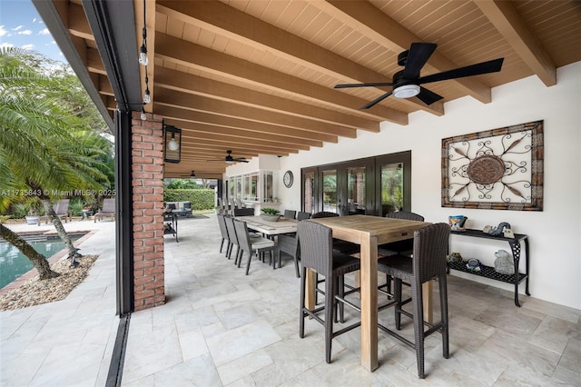 view of patio / terrace with outdoor dining area, a ceiling fan, and an outdoor pool