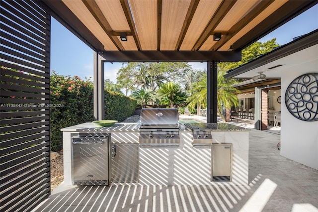 view of patio with an outdoor kitchen and a grill