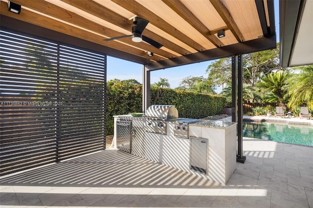 view of patio with fence, a fenced in pool, an outdoor kitchen, ceiling fan, and a grill