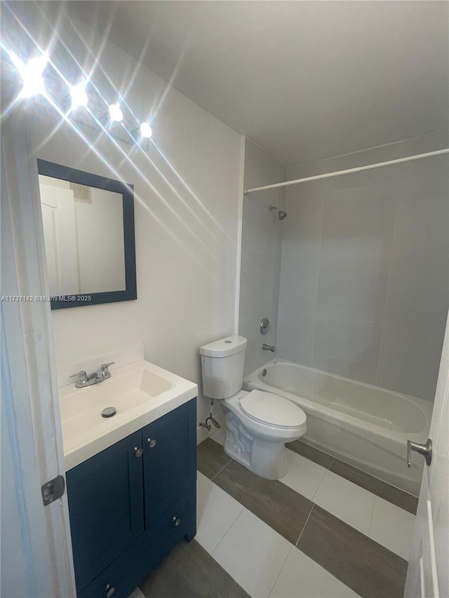 full bathroom featuring tile patterned floors, vanity, toilet, and tiled shower / bath combo