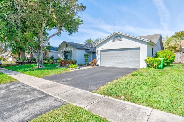 single story home with a garage and a front lawn