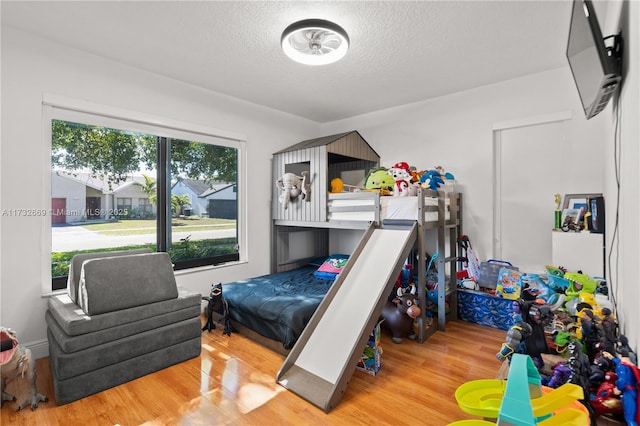 bedroom featuring light hardwood / wood-style flooring and a textured ceiling