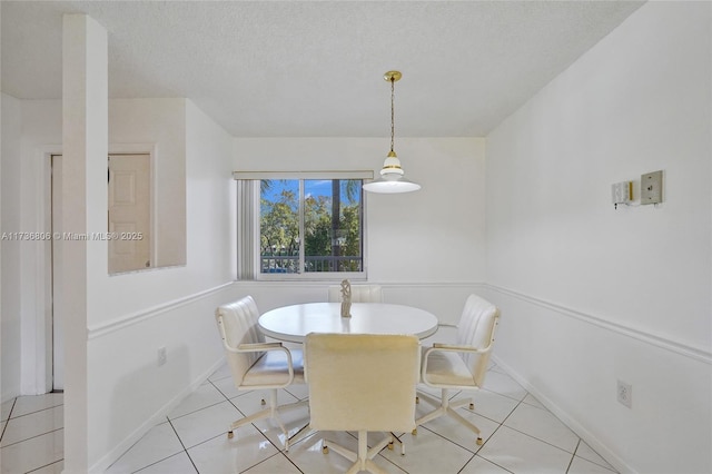 dining area featuring a textured ceiling and light tile patterned flooring