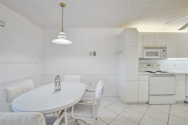 dining space featuring a textured ceiling and light tile patterned floors