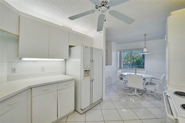 kitchen with decorative light fixtures, white cabinetry, light tile patterned floors, white appliances, and a textured ceiling