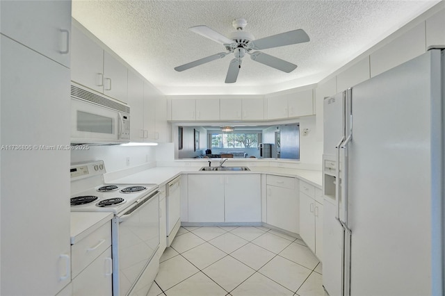 kitchen featuring light tile patterned flooring, sink, white cabinetry, a textured ceiling, and white appliances