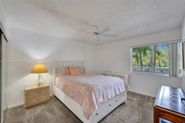 carpeted bedroom featuring ceiling fan and a textured ceiling