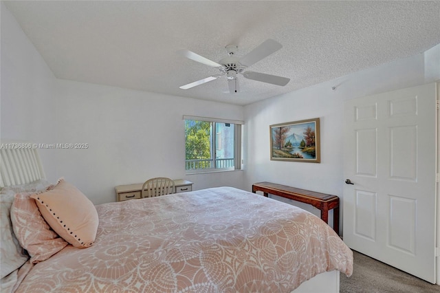 carpeted bedroom featuring ceiling fan and a textured ceiling