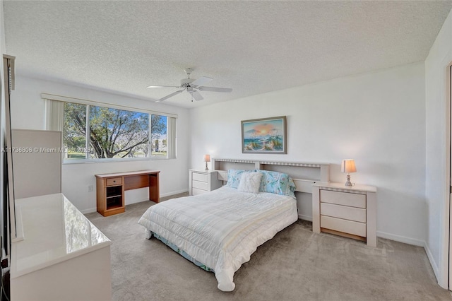 carpeted bedroom featuring ceiling fan and a textured ceiling