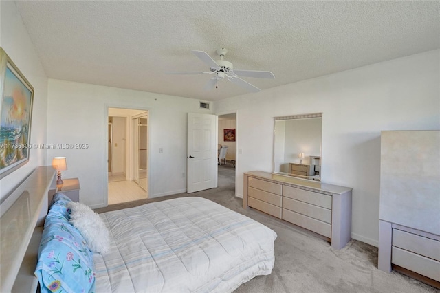 carpeted bedroom with ceiling fan and a textured ceiling