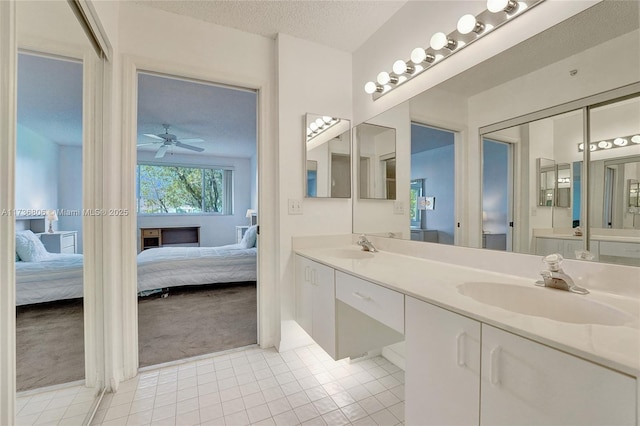 bathroom featuring tile patterned flooring, vanity, a textured ceiling, and ceiling fan