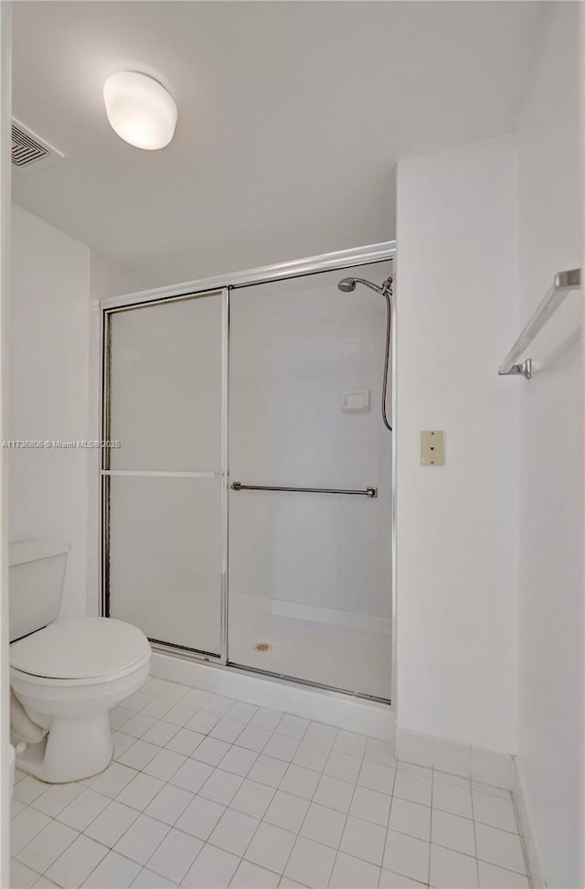 bathroom with toilet, an enclosed shower, and tile patterned flooring