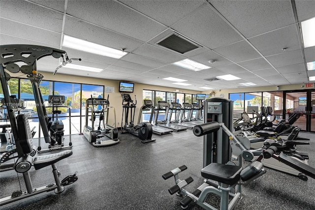 gym with a healthy amount of sunlight and a paneled ceiling