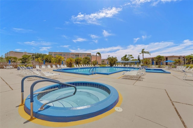 view of swimming pool with a hot tub and a patio