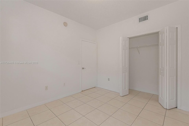 unfurnished bedroom featuring light tile patterned flooring and a closet