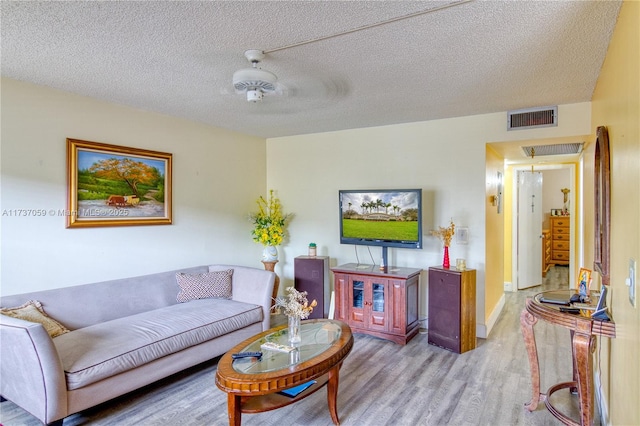 living room with light hardwood / wood-style floors and a textured ceiling