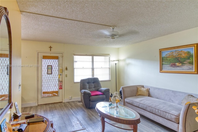 living room featuring hardwood / wood-style floors, a textured ceiling, and ceiling fan