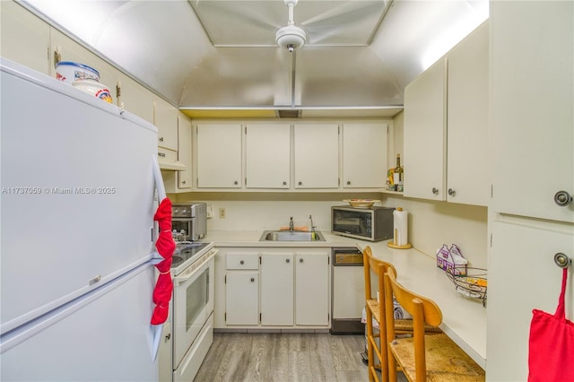 kitchen featuring sink, white cabinets, white appliances, and light wood-type flooring