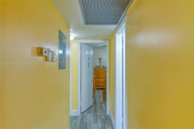 hallway with electric panel and light hardwood / wood-style floors