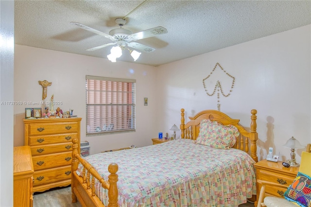 bedroom with ceiling fan and a textured ceiling