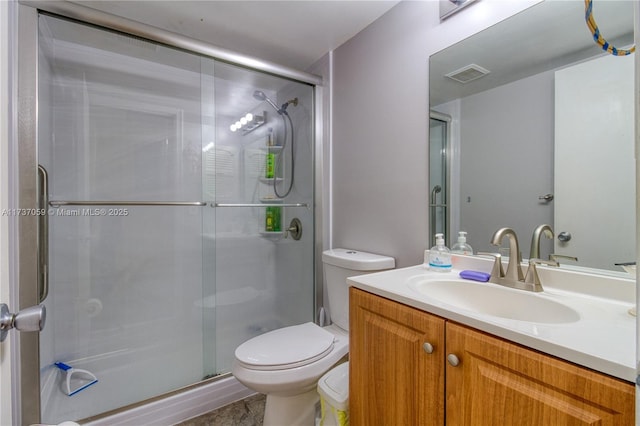 bathroom featuring vanity, toilet, and a shower with door